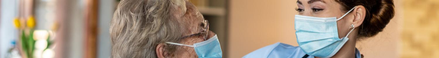 Photo of elderly woman and healthcare provider in living room