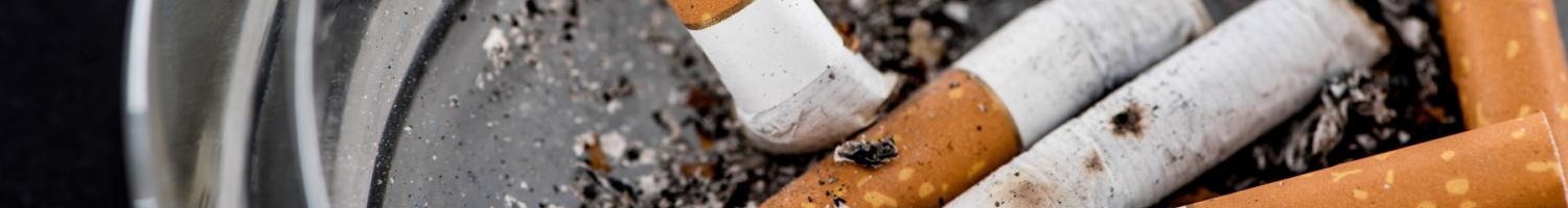 Photo of smoked cigarettes in a glass ashtray