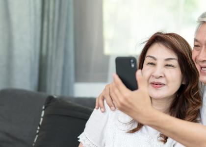 Photo of older Asian couple using a cellphone