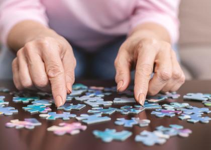 Photo of an older woman working on a jigsaw puzzle