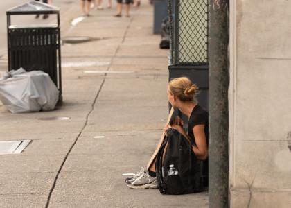 Photo of teenager with backpack panhandling on the street